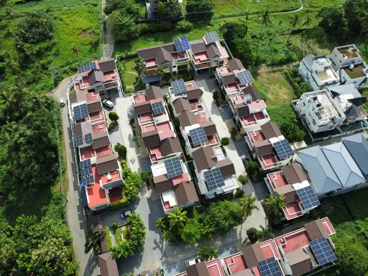 Aerial view of a villa community in Kerala with rooftop solar arrays installed across the development.