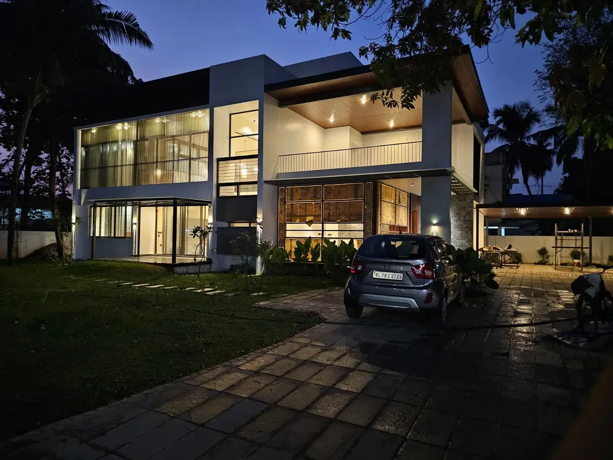 A residence at dusk with every internal and external circuit live: lighting, façade and canopy loads designed and installed by Augzet Engineers.